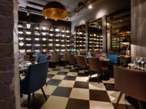 Modern restaurant interior with checkered floor and lighting.