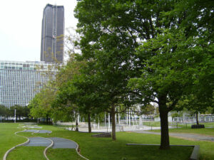 Parc avec arbres et tour moderne.
