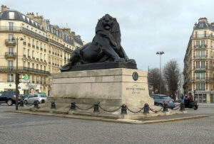 Statue of a lion on a city square.
