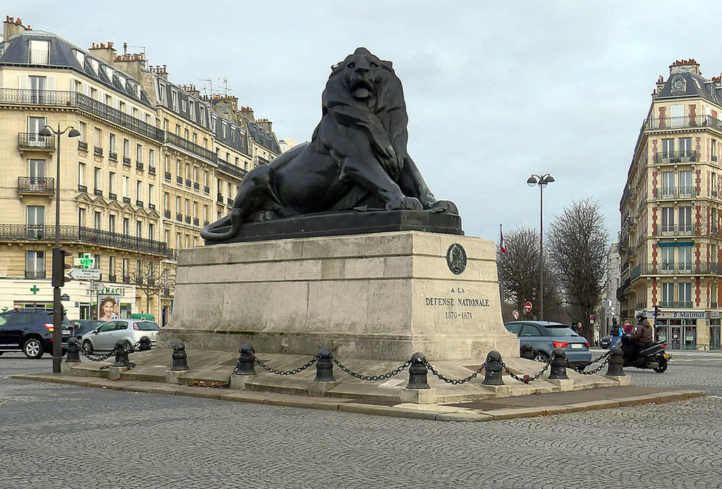 Statue lion place parisienne, bâtiments autour.