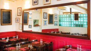 Cozy restaurant interior with framed art and mirrors.